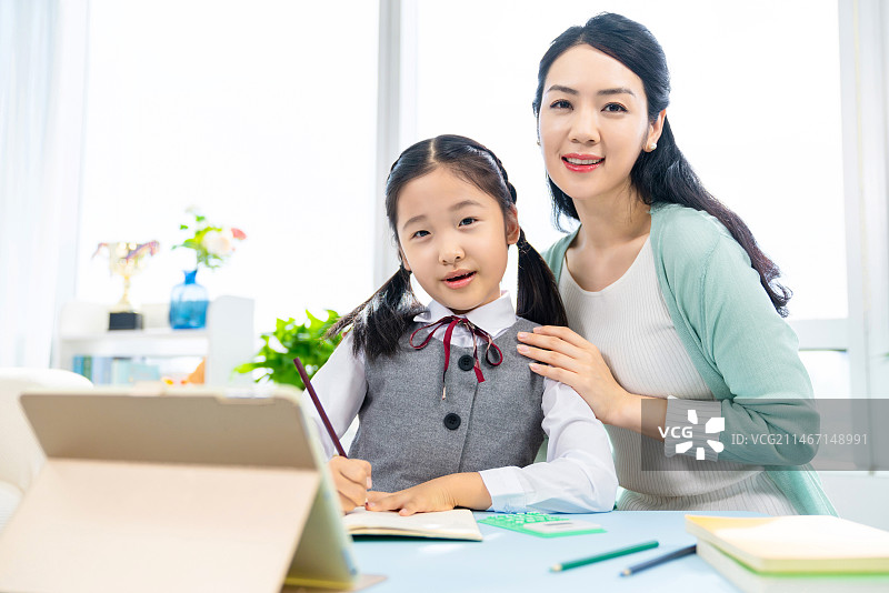 小女孩和妈妈一起使用平板电脑图片素材