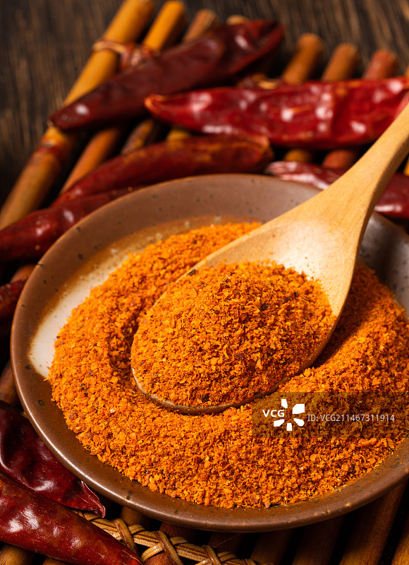 暗色木板上一小碟辣椒粉图片素材