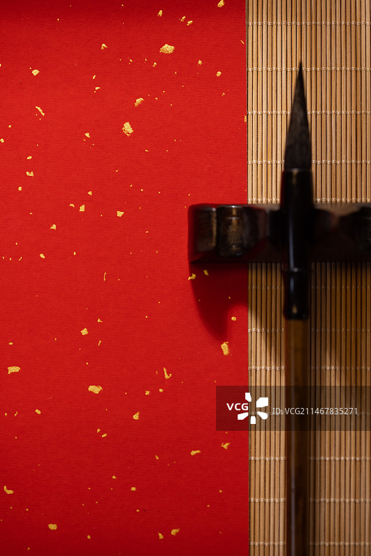 桌上的红色空白宣纸与毛笔特写图片素材