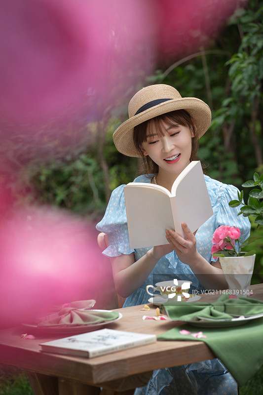 青年美女坐在院子里看书图片素材