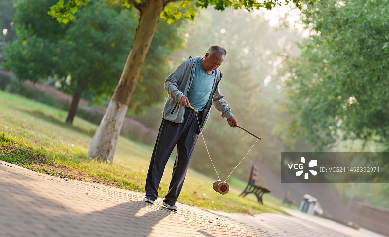 公园内抖空竹的老年人图片素材
