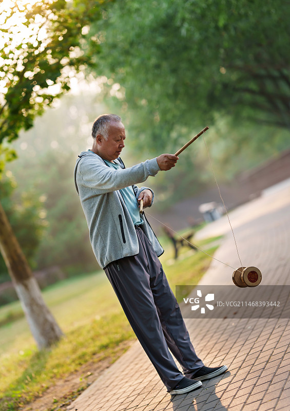 公园内抖空竹的老年人图片素材