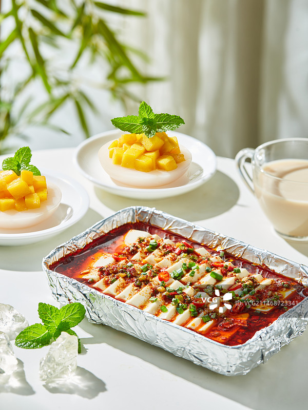 餐桌上的美食香烤锡纸豆腐和钵仔糕图片素材