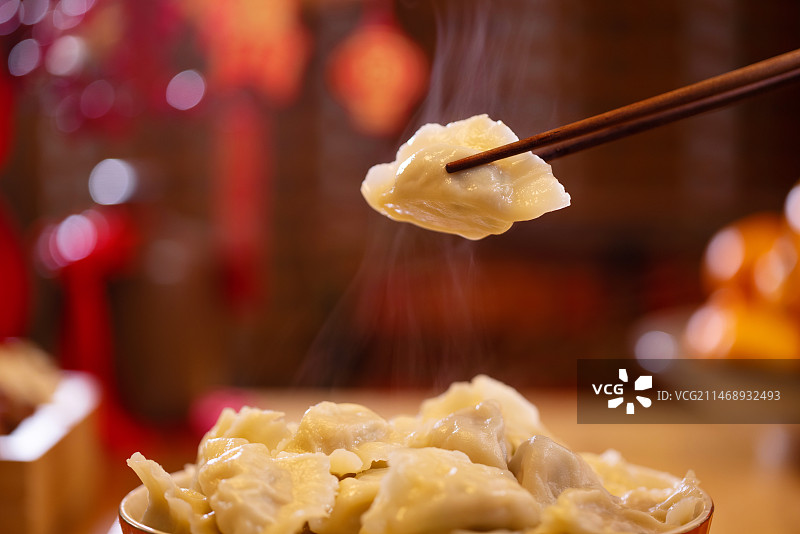 一个饺子被筷子夹到空中特写图片素材