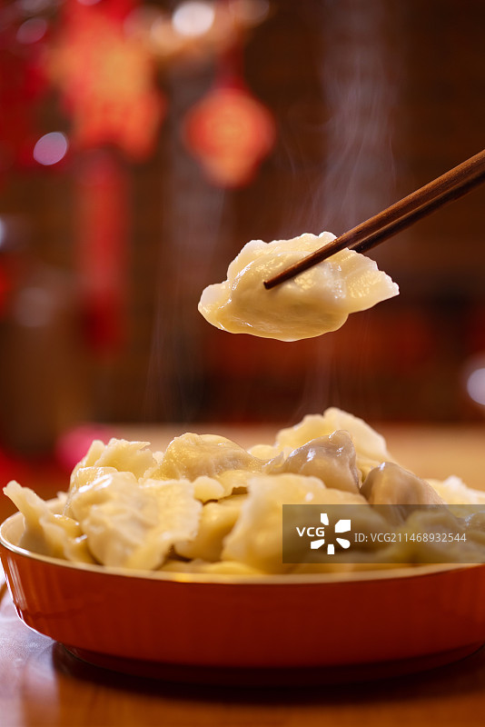 一个饺子被筷子夹到空中特写图片素材