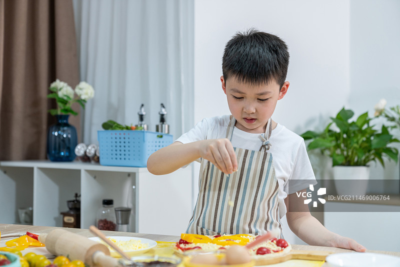 快乐的小男孩做披萨图片素材
