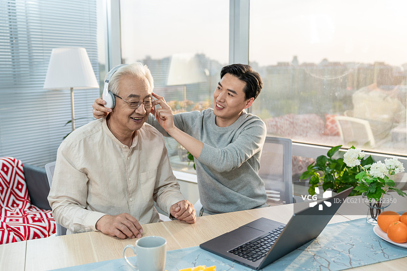 快乐的父子使用笔记本电脑图片素材