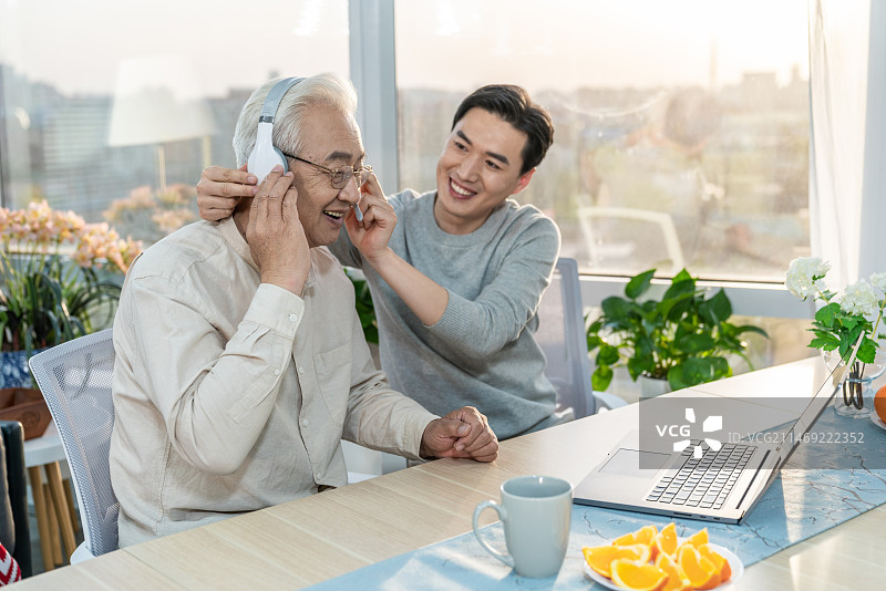 快乐的父子使用笔记本电脑图片素材