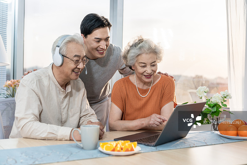 快乐的家庭使用笔记本电脑图片素材