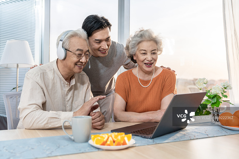 快乐的家庭使用笔记本电脑图片素材