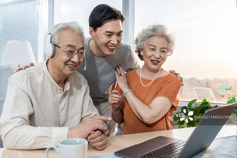 快乐的家庭使用笔记本电脑图片素材