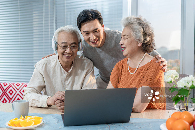 快乐的家庭使用笔记本电脑图片素材