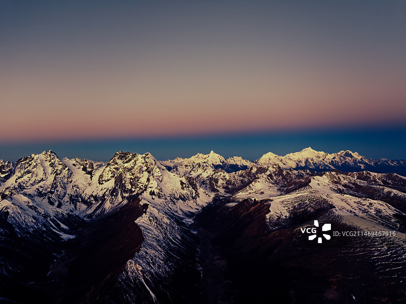 梅里雪山与白马雪山晨昏线日出的同框图片素材