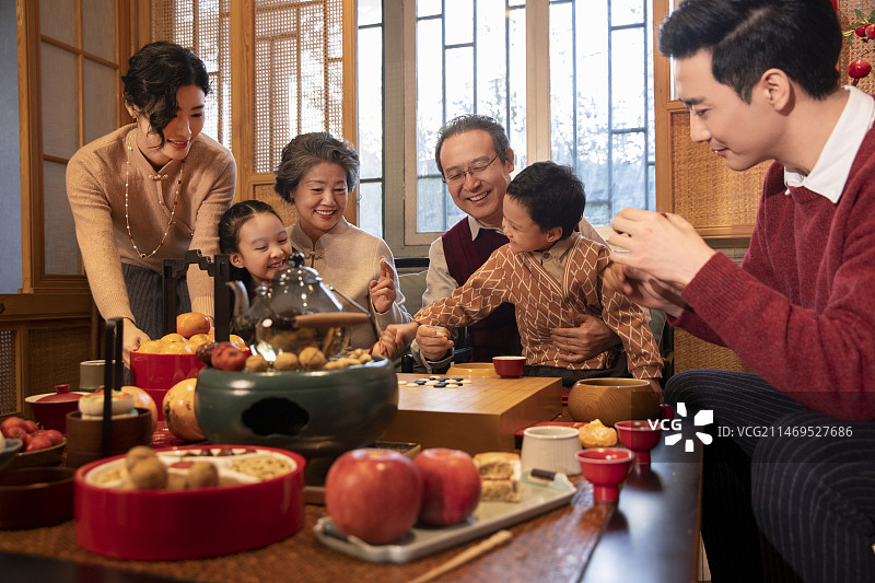东方家庭过年：幸福一家人在客厅玩围棋、聊天嬉戏图片素材