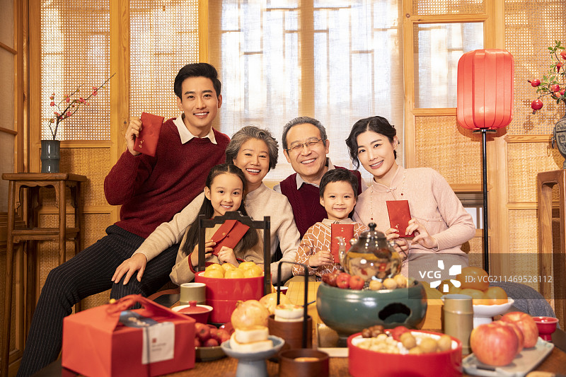 东方家庭过年：幸福一家人在客厅拜年、送红包图片素材
