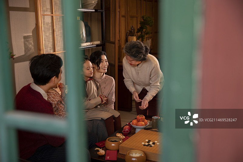 东方家庭过年：幸福一家人在客厅吃水果、聊天嬉戏图片素材