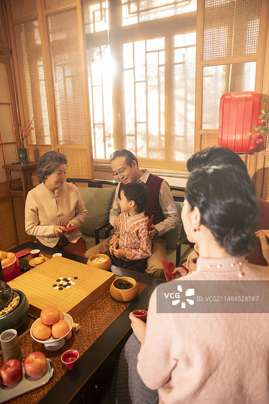 东方家庭过年：幸福一家人在客厅拜年、送压岁红包图片素材