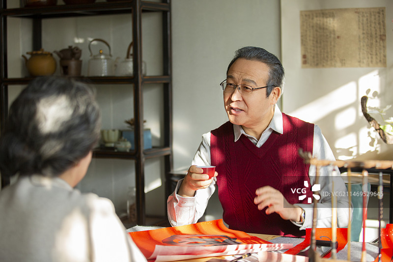 东方家庭过年：老年夫妇在书房喝茶聊天、写春联图片素材