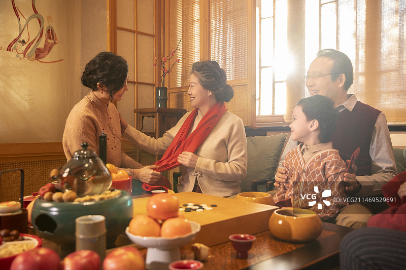 东方家庭过年：青年女子给长辈送围巾图片素材