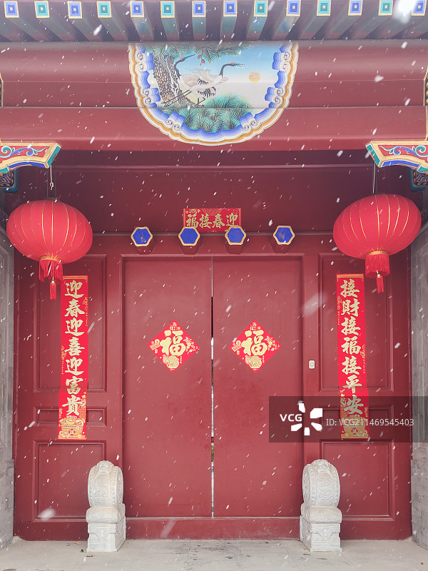 雪中红色贴春联挂红灯笼的中式庭院门前图片素材