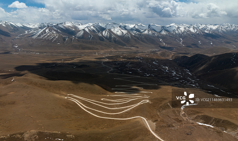 航拍西藏拉萨琼穆岗嘎雪山下的盘山公路图片素材