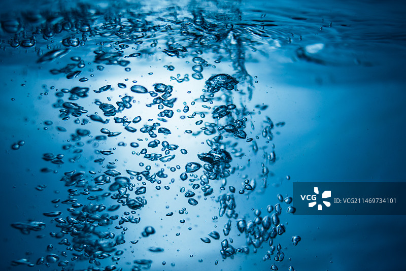 蓝色背景下，水中气泡特写图片素材