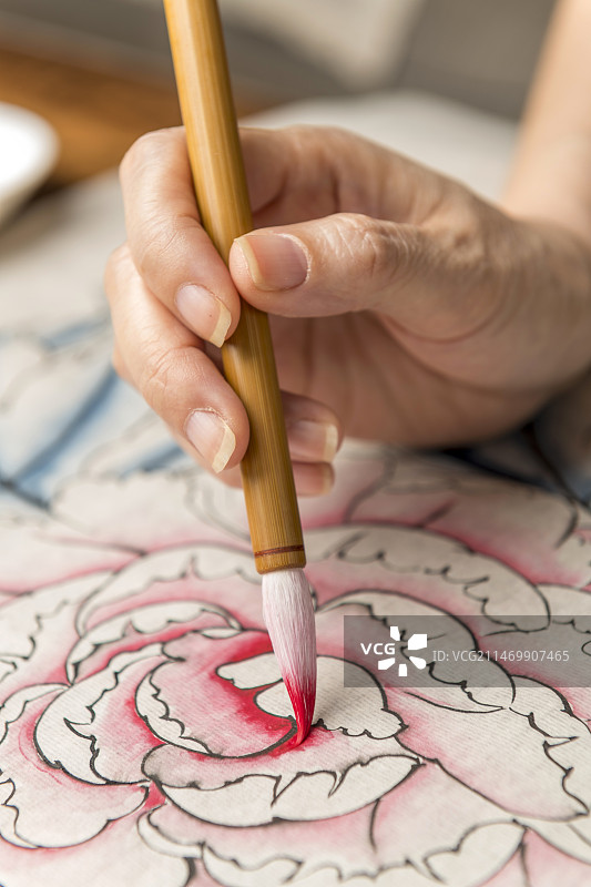 女性手持毛笔绘制国画工笔牡丹特写图片素材