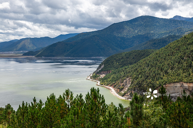 云南迪庆香格里拉市214国道观景台俯瞰纳帕海，还有周边的森林和群山，白昼晴朗天气。图片素材