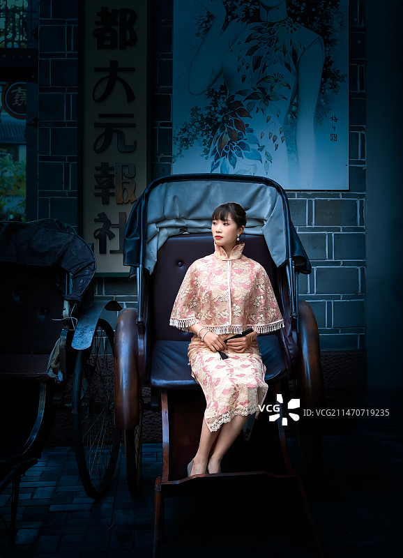 一位穿着旗袍的女人坐在黄包车上图片素材