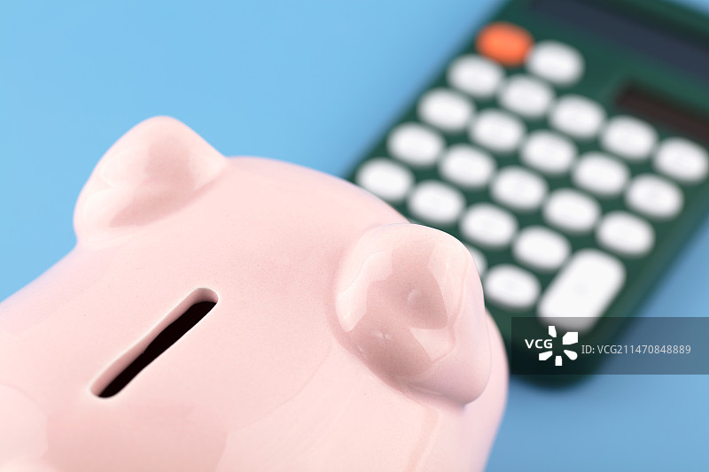 小猪存钱罐看着计算器图片素材