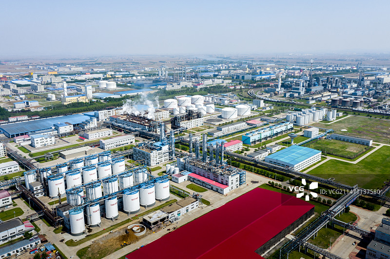 空中俯瞰阳光下晴朗天空城市中的化工厂工业设施图片素材