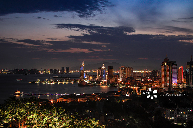 青岛日落时分的栈桥和都市的俯瞰视角图片素材