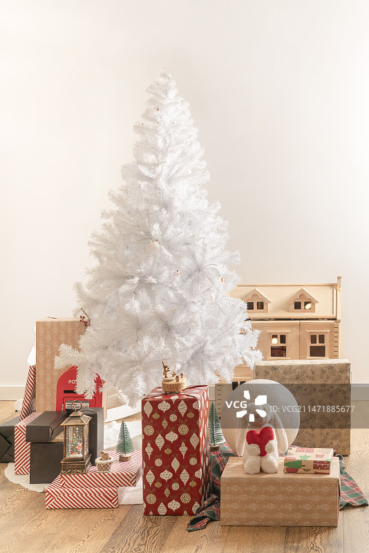 白色圣诞树处的各式各样的儿童圣诞礼盒图片素材