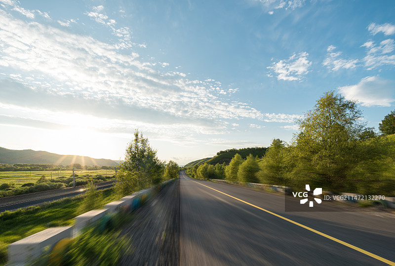 山区草原动感公路路面与夕阳阳光天空背景图片素材