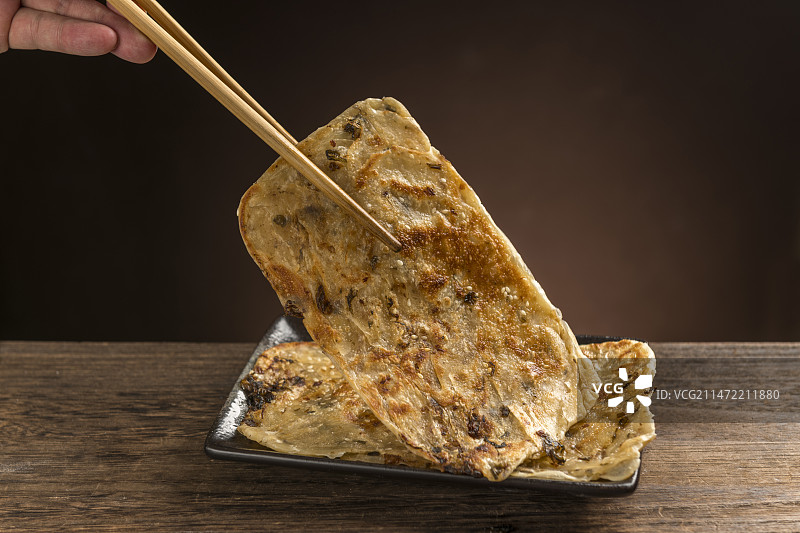 面食小吃锅盔摆放在木桌面上特写深色调图片素材