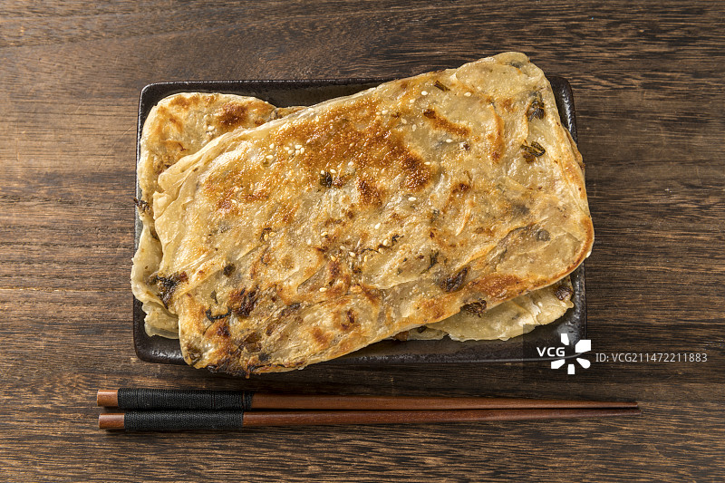面食小吃锅盔摆放在木桌面上特写深色调图片素材