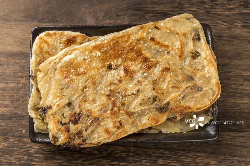 面食小吃锅盔摆放在木桌面上特写深色调图片素材