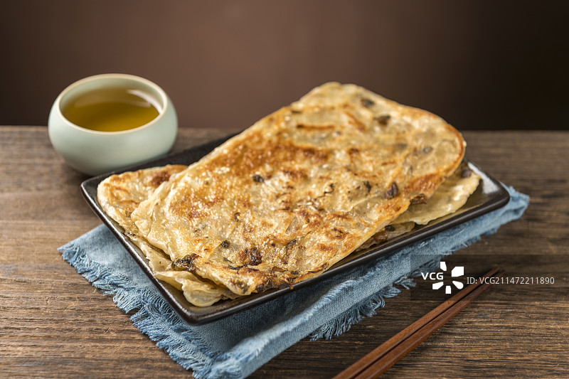 面食小吃锅盔摆放在木桌面上特写深色调图片素材