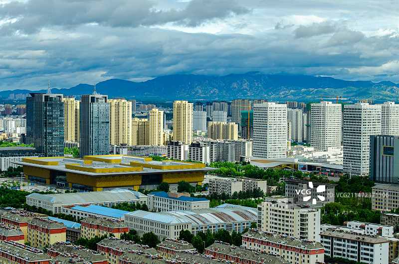 中国城市市风光拍摄主题，山东省泰安市泰山区，傲徕峰山脉和天空的乌云和城市居住区，户外白昼无人图像摄影图片素材