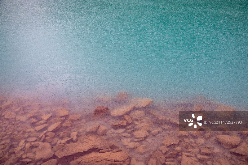 川西丹巴党岭甲依拉措雨中湖水岩石的高角度视图图片素材