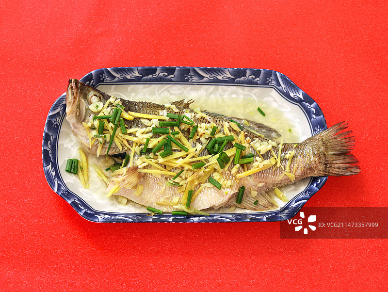 红色背景上的一盘中餐清蒸鱼图片素材