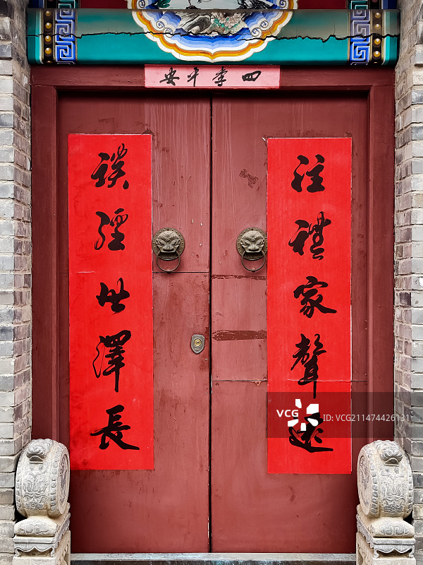 秋天里晴朗的天气，北京胡同街头，四合院民居古建筑的正门大红门和春联福字。图片素材