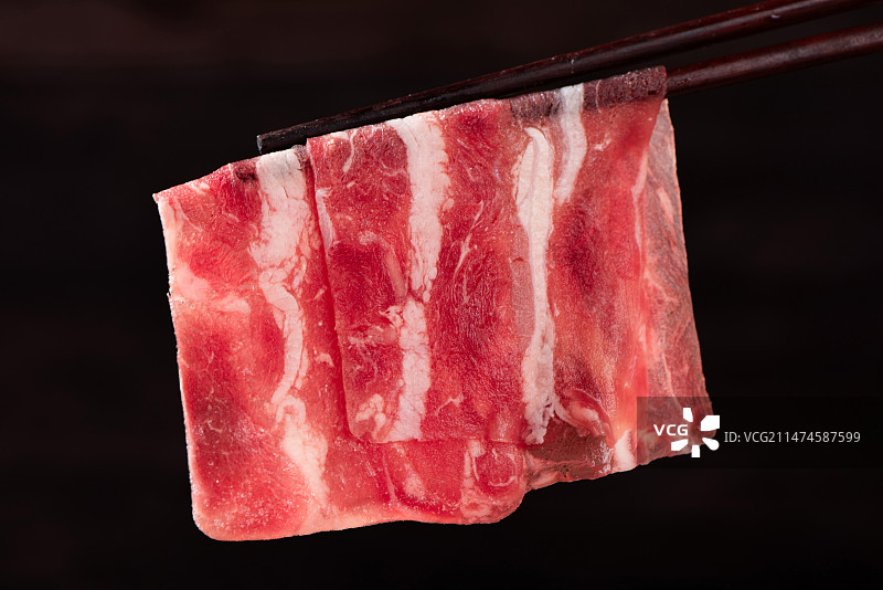 筷子夹起的牛肉卷特写图片素材