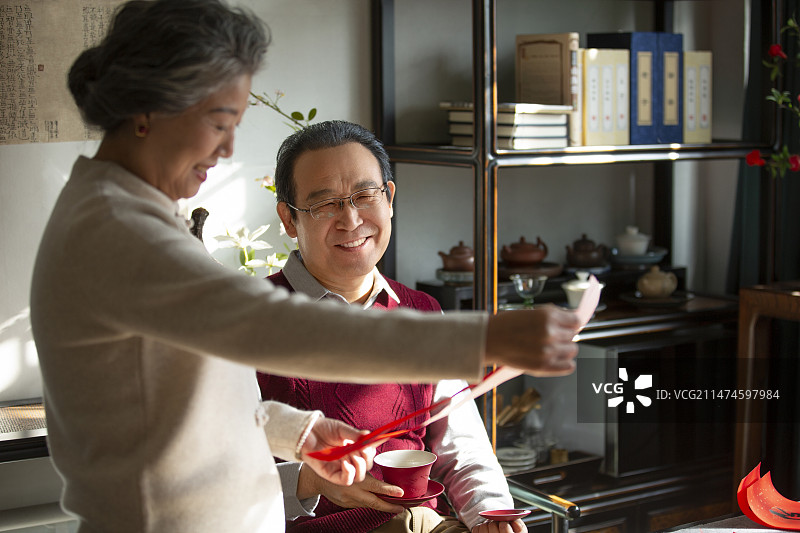 东方家庭过年：老年夫妇在书房看春联、喝茶、聊天图片素材