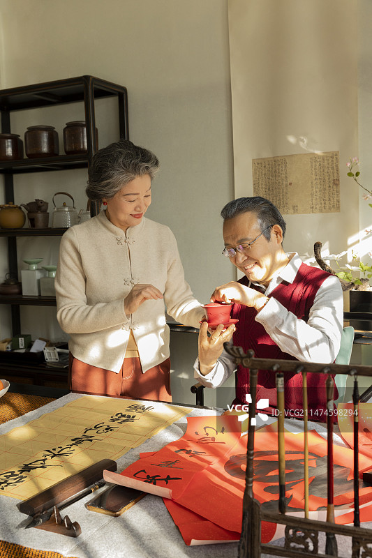 东方家庭过年：老年夫妇在书房喝茶、聊天、写毛笔字图片素材