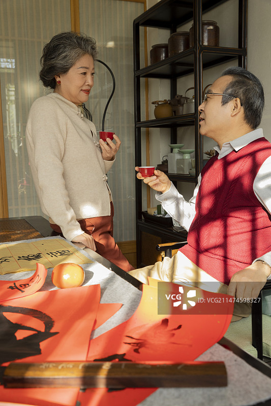 东方家庭过年：老年夫妇在书房喝茶、聊天、写春联图片素材