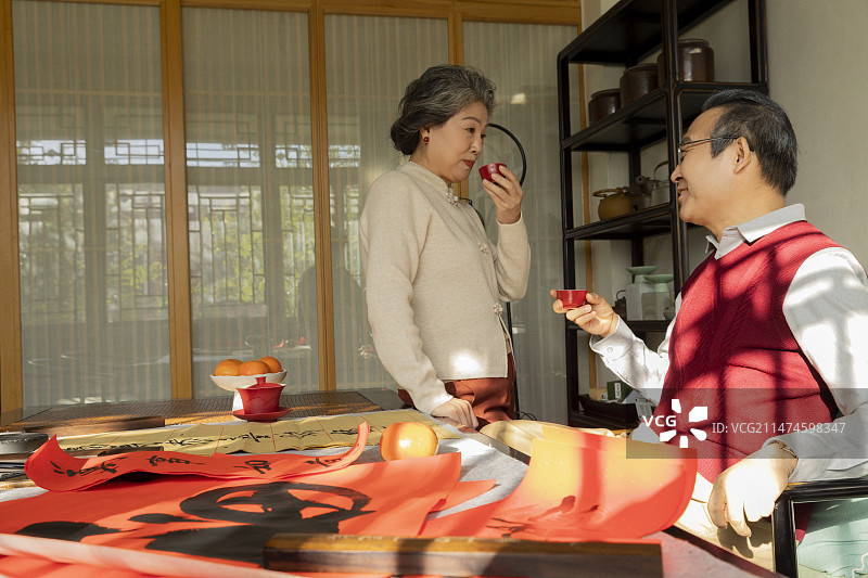 东方家庭过年：老年夫妇在书房喝茶、聊天、写春联图片素材