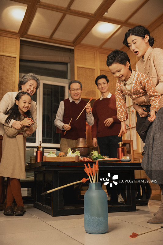 春节一家人吃年夜饭、玩投壶游戏图片素材