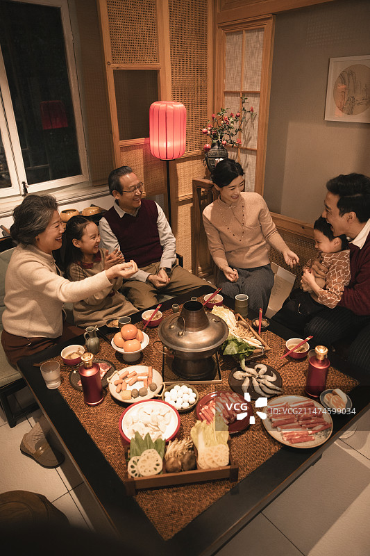 东方家庭过年：幸福一家人在客厅吃年夜饭、玩游戏图片素材