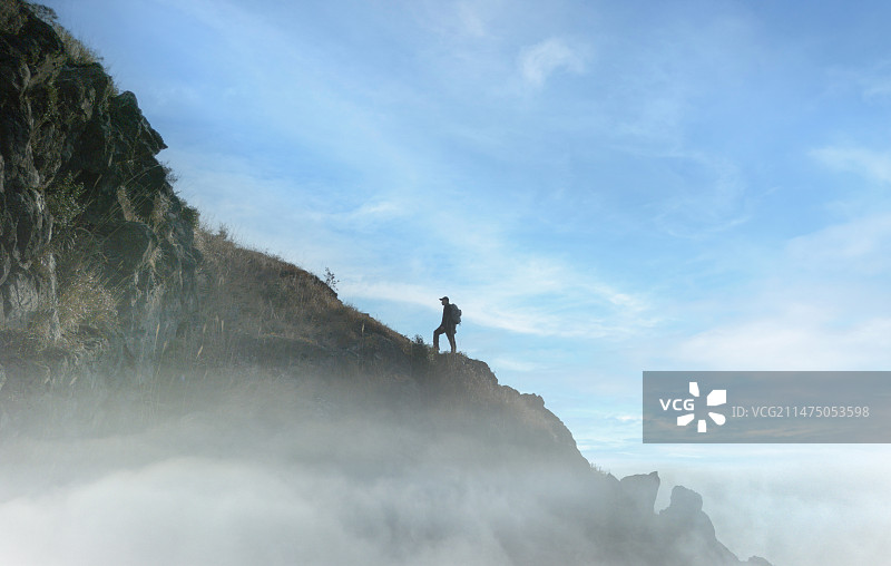一个人登山站在山顶图片素材